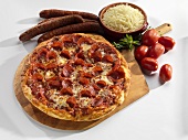Pizza mit Peperoniwurst, umgeben von Zutaten