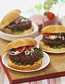 Grilled Blue Cheese Burgers with Onion and Tomato on Buns, Paper Plates