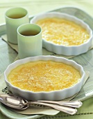 Two Servings of Crème Brulee with Two Cups of Tea on a Tray