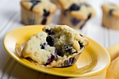 Blueberry Muffin Split Open on a Yellow Plate