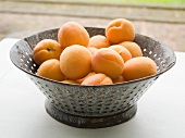 Mehrere frische Aprikosen in einem Durchschlag aus Metall