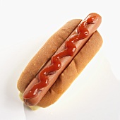 Ein Hot Dog mit Ketchup vor weißem Hintergrund