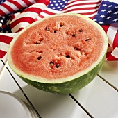 Half of a Watermelon on a Picnic Table with American Flags