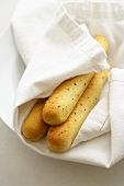 Three Bread Sticks Wrapped in White Linens; From Above