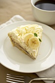 Slice of Banana Cream Pie on a White Plate; With Coffee
