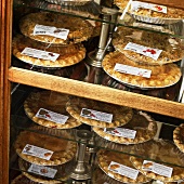 Assorted Sweet Pies in Packaging Displayed in a Bakery Case