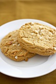Two White Chocolate Chip Cookies with Almonds on a Plate