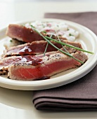 Seared Tuna Sliced on a Plate with Chive Garnish