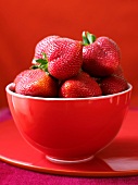 Fresh strawberries in a red bowl