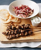Beef Kabobs with Flatbread and Cabbage Slaw on a Board