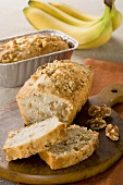 Partially Sliced Banana Nut Loaf Cake; On Cutting Board and Pan