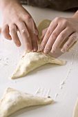 Child Sealing Edges of Meat Filled Pastries