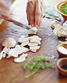 Chef Slicing Garlic on Cutting Board