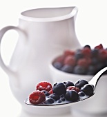 Spoonful of Blueberries and Raspberries in Milk