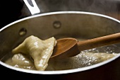 Cooking Kreplach in a Skillet; Wooden Spoon