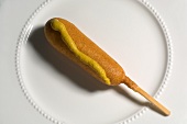 Corn Dog with Mustard on a White Plate