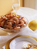 Gekochte Shrimps in Glasschüssel, Gedeck und Zitrone