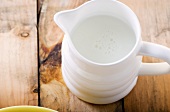 Small Pitcher of Fat Free Milk on Wooden Table