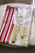 Antique Silverware on Folded Cloth Napkin on Plate