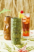 Cocktails in Two Tiki Glass with Fruit Cocktail in a Glass