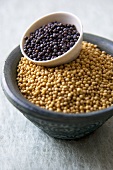Small Bowl of Black Mustard Seeds in Larger Bowl of White Mustard Seeds