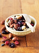 Snack Mix; Nuts and Dried Fruit in a Bowl with Measuring Cup Scoop