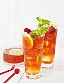 Two Glasses of Iced Tea with Raspberries and Lemon Slices