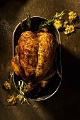 Roasted Game Hen with Wild Flowers and Rosemary in Pan