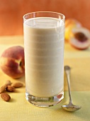 Peach Smoothie in a Glass; Spoon and Peaches
