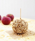 Toffee apple coated with chopped peanuts