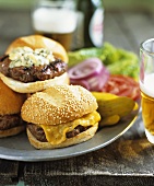 Various Cheeseburgers on Buns; Pickles and Beer