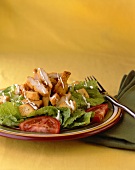 Salat mit frittiertem Hähnchen, Dressing und Tomaten