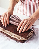 Woman Preparing Cream Filled Cake Roll