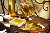 Hand giesst kaltgepresstes Olivenöl aus Karaffe in Schale