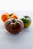 Three heirloom tomatoes (red, orange and green)