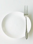 White Plate with an Antique Fork; White Background