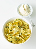 Bowl of Fresh Pasta with Pesto and Parmesan Cheese; Parmesan Cheese in a Bowl