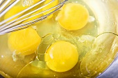 Cracked Eggs in a Bowl with Whisk