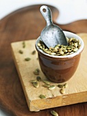 Small Bowl of Roasted Pumpkin Seeds with a Small Metal Scoop