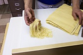 Mann zeigt selbstgemachte Nudeln (Borgatti's, Little Italy, New York)