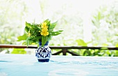 Yellow Wildflowers in a Small Blue Vase on a Table