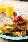 Stack of French Toast with Maply Syrup and Strawberries; Orange Juice