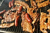 Assorted Meat and Sausage Cooking on a Grill
