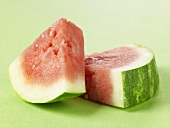 Two Watermelon Wedges on Green Surface