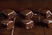 Pralinen werden in flüssige Schokolade getaucht