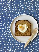 Heart Shaped Fried Egg on Slice of Whole Grain Toast; Fork