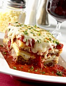 Piece of Lasagna with Tomato Sauce on a White Plate