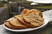 Scones und Brot auf Holzzaun am Meer (Aran Island, Irland)