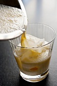 Pouring Milk Punch into a Glass with Ice