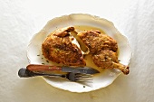 Crisp Brick Chicken on a Platter with Fork and Knife